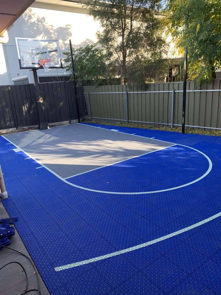 Navy blue and grey tiled court beside a covered alfresco area
