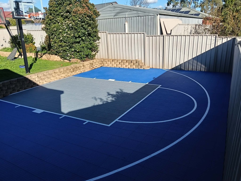 Navy and grey tiled court set behind a brick retaining wall