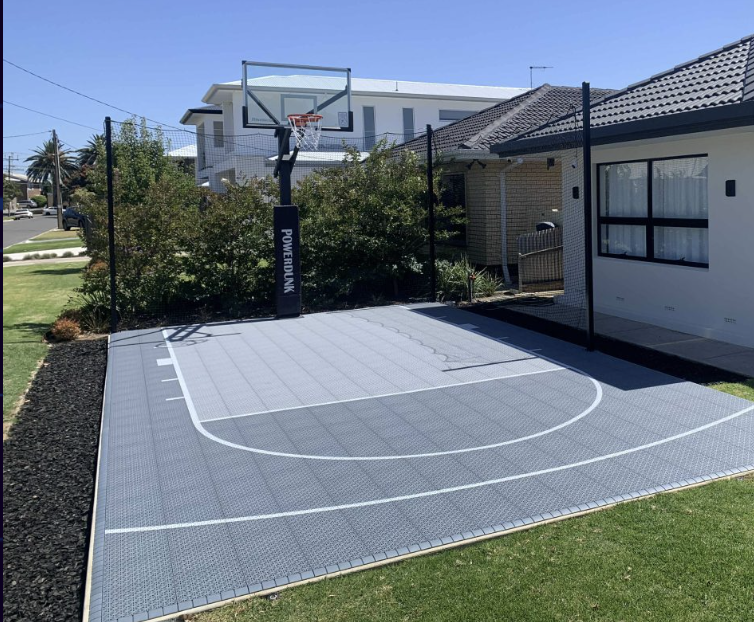 Backyard basketball court with grey tiles, white lines and black key