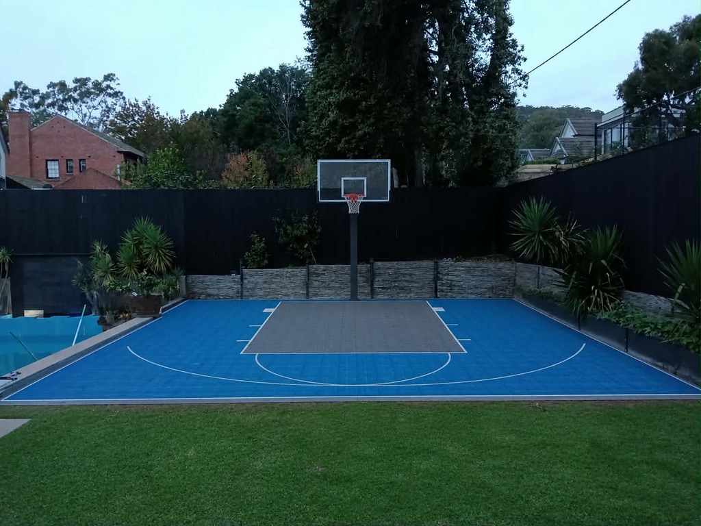 Blue acrylic-finish court with grey key beside a pool
